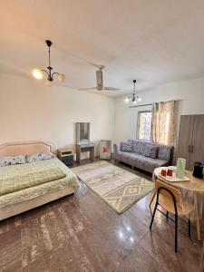 a bedroom with a bed and a couch and a table at Farno Hostel in Muscat