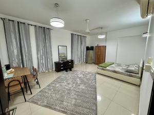 a bedroom with a bed and a table and a dining room at Farno Hostel in Muscat +4 photos