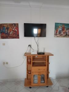 a tv on a wall with a wooden table at Casa youssef 2 in Asilah