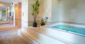 ein großes Badezimmer mit einer Badewanne, in der Pflanzen stehen in der Unterkunft Fourvière Hôtel in Lyon