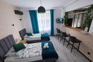 a living room with two beds and a bar at Apartament Zacisze 2 in Przemyśl