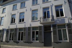 Un edificio blanco con ventanas y balcón. en B&B Huyze Weyne, en Brujas