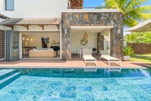 a villa with a swimming pool in front of a house at Ama Villas - Luxury Private Villas in Mont-Choisy Beach in Mont Choisy