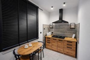 a kitchen with a wooden table and a stove at Apartament Zacisze 2 in Przemyśl