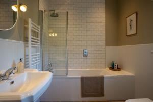 a bathroom with a tub and a sink and a shower at Skinnel Cottage in Kirkcudbright +15 photos
