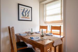 a dining room table with chairs and a wooden table sidx sidx sidx sidx at Skinnel Cottage in Kirkcudbright