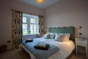a bedroom with a bed with two towels on it at Skinnel Cottage in Kirkcudbright