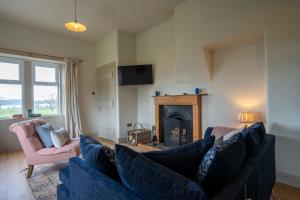 a living room with a blue couch and a fireplace at Skinnel Cottage in Kirkcudbright