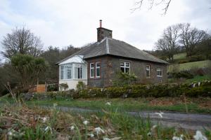 a small brick house with a chimney on top of it at Skinnel Cottage in Kirkcudbright