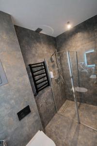 a bathroom with a shower with a glass door at Apartament Zacisze 2 in Przemyśl