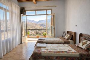 a room with two beds and a large window at Birhanu Guest House and Tours in Lalibela