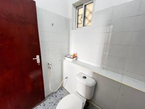 a bathroom with a toilet and a window at Azure Stays in Mombasa