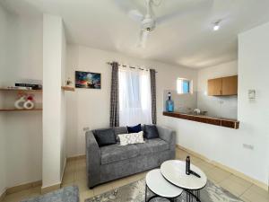 a living room with a couch and a table at Azure Stays in Mombasa