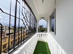 a balcony with a green floor and windows at Azure Stays in Mombasa