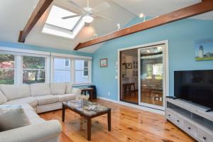 a living room with a couch and a tv at Private Pool Large Deck and Game Room in Dennis +28 photos