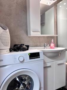 a kitchen with a washing machine and a sink at Relax - Patras Apartment in Patra +19 photos