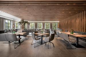 a restaurant with wooden walls and tables and chairs at Hotel VierJahreszeiten am Seilersee in Iserlohn +119 photos
