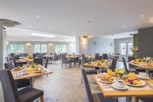 a restaurant with tables and chairs with food on them at Gîte du Vieux Moulin in Rochefort