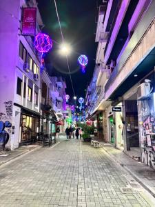 an empty street at night with colorful lights at Relax - Patras Apartment in Patra