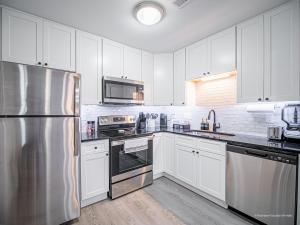 a kitchen with white cabinets and a stainless steel refrigerator at The Battery Hideaway in Marietta