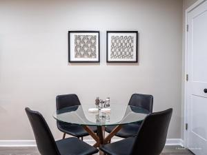 a dining room with a glass table and black chairs at The Battery Hideaway in Marietta +7 photos