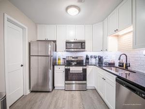 a kitchen with white cabinets and stainless steel appliances at The Battery Hideaway in Marietta