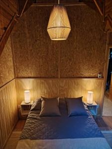 a bedroom with a blue bed with two lamps at Bosque Hostel in Villa Traful