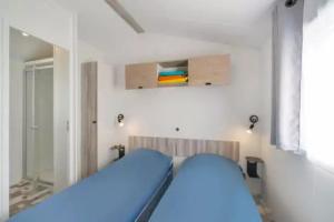 a bedroom with a blue bed in a room at Camping 5 étoiles - Parc aquatique - eecdae in Saint-Jean-dʼOrbetiers +18 photos