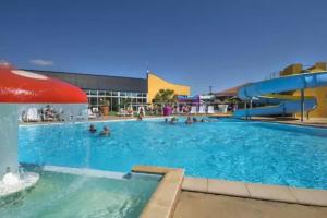 a pool at a resort with people in the water at Camping 5 étoiles - Parc aquatique - eecdae in Saint-Jean-dʼOrbetiers