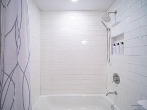 a white bathroom with a shower and a tub at The Franklin in Marietta in Marietta