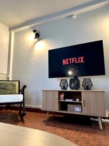 Ein Fernseher an der Wand mit einem Netflix-Logo. in der Unterkunft Le Conki ( Parking gratuit ) in Chartres