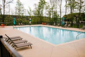 a large swimming pool with lounge chairs and tables at BEAUTIFUL Jasper Highlands Cabin - AZALEA in Jasper