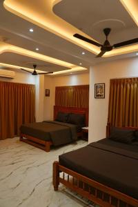a bedroom with two beds and a ceiling at Lillas White house in Arpora