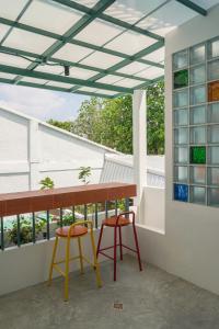 a balcony with a table and two chairs at Arunne in Bangkok Yai