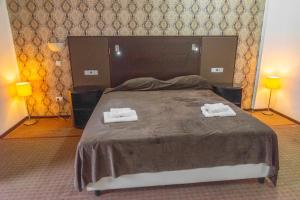 a bedroom with a bed with two towels on it at Hotel Parc in Onești