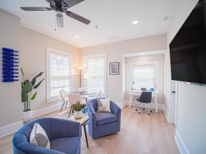 a living room with blue chairs and a table at The Maison at Marietta Square in Marietta