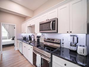 a kitchen with white cabinets and a black counter top at The Maison at Marietta Square in Marietta +23 photos