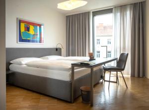 a bedroom with a bed and a desk and a window at Lendhotel in Graz +31 photos