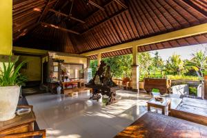 an outdoor living room with a table and chairs at Asri Sari Villa Ubud in Ubud