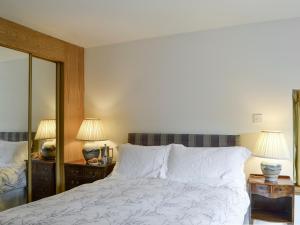 a bedroom with a bed with two lamps and two mirrors at Shedend in Kingston