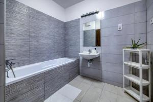 a bathroom with a tub and a sink and a toilet at Villa Oliver 2 Budapest in Budapest