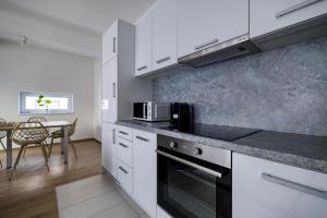 a kitchen with white cabinets and a table with a microwave at Villa Oliver 2 Budapest in Budapest