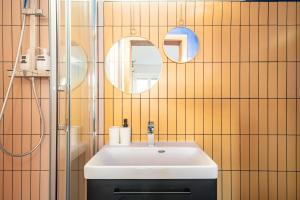 a bathroom with a white sink and two mirrors at Strasbourg Evasion Pop in Strasbourg +27 photos