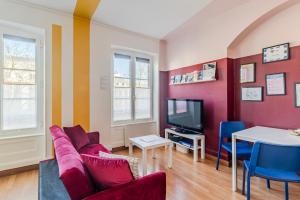 a living room with a couch and a tv at Strasbourg Evasion Pop in Strasbourg