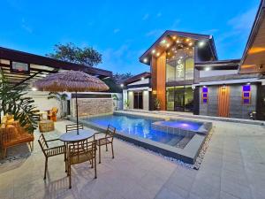 a house with a pool and a table and chairs at Heaven staycation in Angeles
