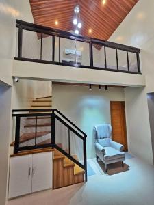 a loft bed in a house with a chair and a staircase at Heaven staycation in Angeles +1 photo