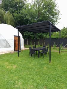 Ein schwarzes Sonnensegel mit Stühlen und einem Tisch in einem Garten in der Unterkunft Glamping Vaqueros in Vaqueros + 5 Fotos