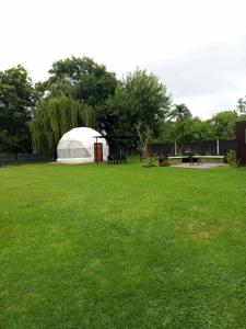 ein weißes Zelt auf einer grünen Wiese in der Unterkunft Glamping Vaqueros in Vaqueros