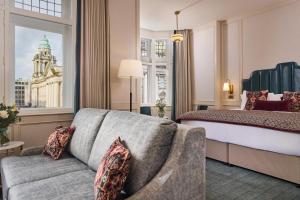 a hotel room with a bed and a couch at The Bedford Hotel Belfast in Belfast