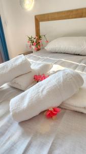 two beds with white towels and flowers on the floor at Maré Varna in Varna City
